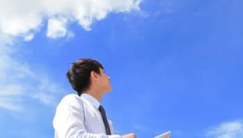 young business man using tablet pc and look to blue sky